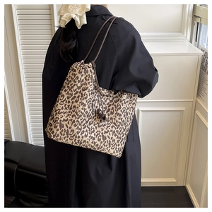Sac fourre-tout léopard avec cordon de serrage et lanières en cuir sur un manteau noir