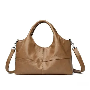 Detail of camel brown patchwork tote bag showing soft leather texture and cross stitching