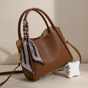 Elegant brown pebbled leather tote bag with stylish striped silk scarf and gold hardware