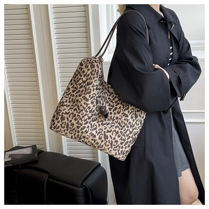 Détail du sac cabas en toile à imprimé léopard avec cordon de serrage et anses en cuir