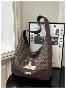 Detail of canvas tote bag featuring houndstooth patchwork and a cute calico cat illustration