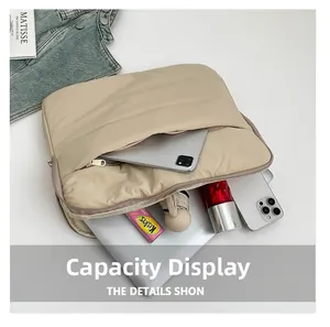 Detail der Innenkapazität mit Laptop, Tablet und Handy in der gesteppten beigen Tragetasche
