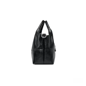 Side view of black faux leather tote bag showing metallic silver rings and textured surface