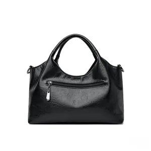 Detail of black oil wax PU leather handbag with silver zipper pocket and round handles