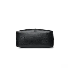 Detail of reinforced stitching and lychee grain leather on the handbag bottom base