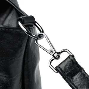 Macro detail of high-quality leather texture and gunmetal lobster clasp on the black handbag