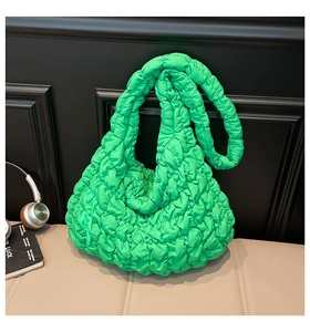 Detailstruktur des leuchtend grünen gesteppten Smocking-Stoffs einer großen Puffer-Tasche