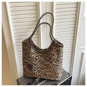 Détail du sac cabas à imprimé léopard avec brides en cuir marron et pendentif coeur