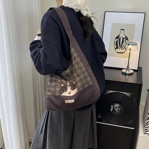 Chic houndstooth canvas tote bag with cat graphic shown in a stylish indoor setting
