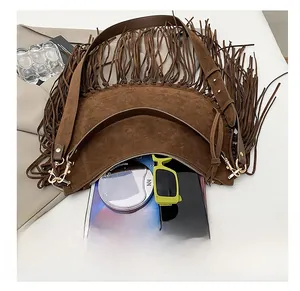 Detail view of the spacious interior of a brown suede hobo bag with bohemian fringes
