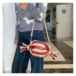 Detail of candy-shaped crossbody bag featuring red and white stripes and thin strap