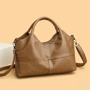 Close-up of soft leather stitching and sturdy handles on a vintage brown tote bag