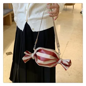 Detail of candy-shaped crossbody bag featuring red and white stripes and a metal lock