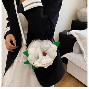 Detail of creative floral crossbody bag with white petals, pearls, and red core accent