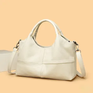 Close-up of beige lychee texture leather handbag with stylish cross-stitch detail