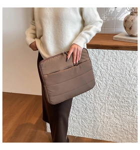 Detailansicht der braun gesteppten Laptoptasche mit Doppelreißverschluss und Seitentasche