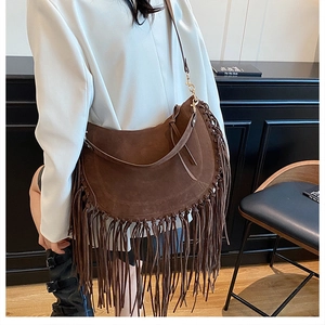 Close-up of deep brown suede hobo bag with long fringes in a bohemian retro style