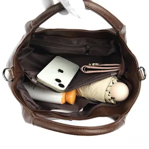 Detail view of the spacious inner compartments of this dark brown pebbled leather handbag