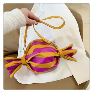 Detail of candy-shaped crossbody bag with yellow and purple stripes and silver hardware