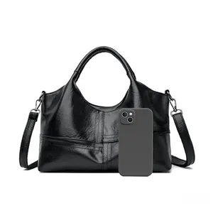 Detailed view of the soft leather texture and reinforced stitching on a black tote bag