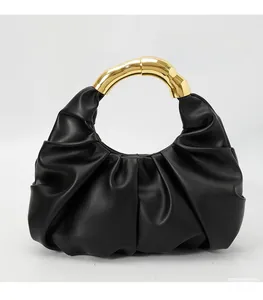 Close-up of black ruched cloud bag with premium golden metal semi-circle handle
