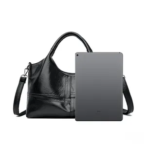 Large black leather tote bag shown with an iPad to demonstrate spacious capacity