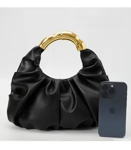 Detail of black pleated dumpling bag showing leather texture and gold metal handle