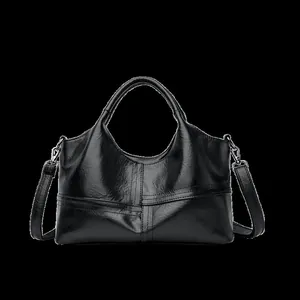 Detail of black soft leather handbag showing geometric patchwork and metal hardware