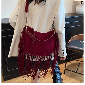Detail of burgundy fringe tote bag in premium faux suede featuring bohemian tassels