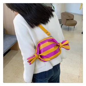 Detail of candy-shaped crossbody bag featuring purple and yellow stripes and bow knot