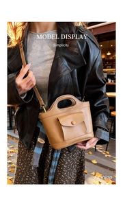 Close-up of vintage brown mini bucket bag with snap pocket and top handle in outdoor setting