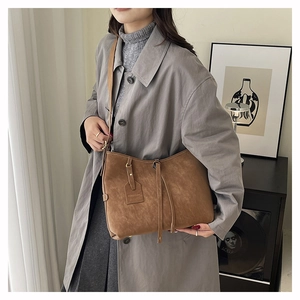 Close-up of brown vintage tote bag featuring fashion tag and matte leather texture