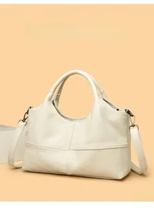 Detail of cream faux leather handbag featuring geometric stitching and metal hardware