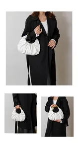 Detail of white pleated cloud bag featuring premium gold metallic arc handle design