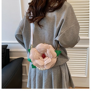 Detail of pink flower crossbody bag featuring faux pearls and layered 3D petals
