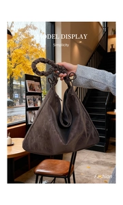 Detailed view of the dark brown suede tote bag featuring unique pleated handles