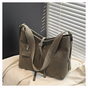 Detail of dark grey tote bag featuring matte texture and fashion tag with soft lighting