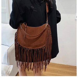 Detail view of dark brown suede hobo bag with long fringes and gold buckle hardware