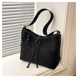 Close-up of black retro minimalist tote bag with contrast stitching and leather tag