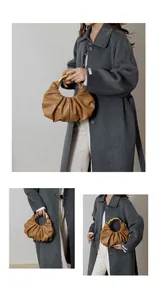 Detail of caramel brown ruched cloud bag with polished gold ring metal handle and leather texture