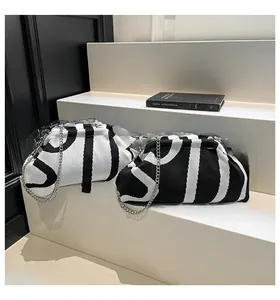 Close-up of knit shell bag with black and white jacquard pattern and silver chain strap
