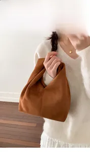 Close-up of a brown suede croissant bag with a soft pleated texture for a chic look