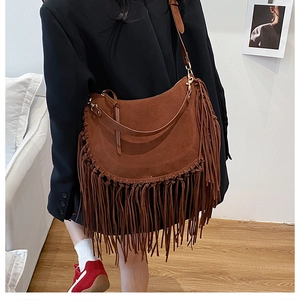 Brown suede shoulder bag featuring long fringe tassels and a curved retro design