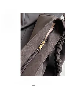 Close-up of premium gold metal zipper on minimalist textured leather shoulder bag