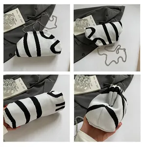 Detail of knitted cloud bag with black stripes and silver chain strap for women