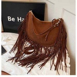 Detail of vintage brown suede crossbody bag with long fringes and metal zipper closure