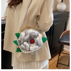 Detail view of silver camellia petal handbag with faux pearls and floral design