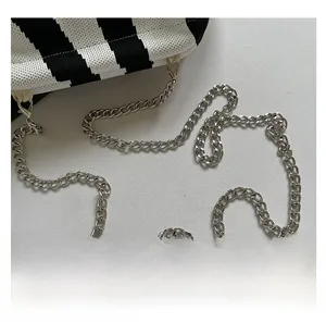 Detail of silver chain strap on black and white striped knitted shoulder bag
