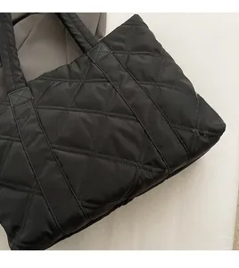 Dettaglio ravvicinato del tessuto trapuntato nero di una borsa tote imbottita grande