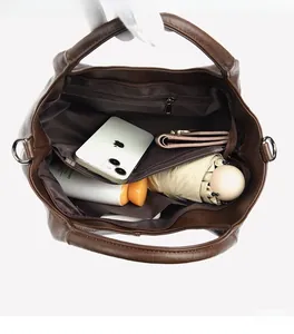 Deep brown leather tote bag interior showing large capacity with functional zip pockets